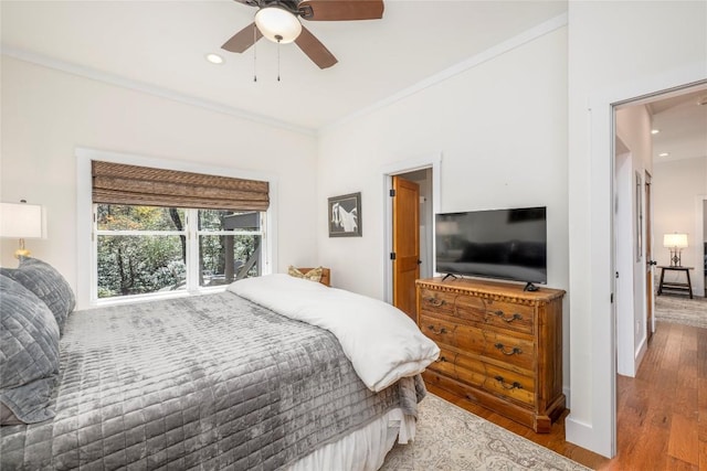 bedroom with crown molding, recessed lighting, and wood finished floors