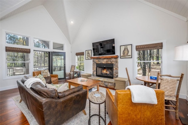 living area featuring high vaulted ceiling, plenty of natural light, hardwood / wood-style flooring, and a fireplace