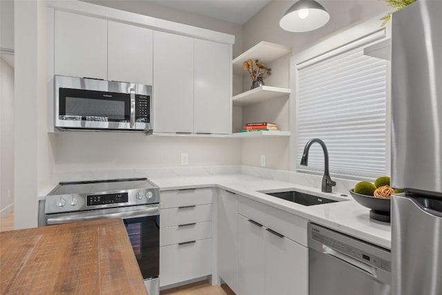 1077 Hicks Rd Unit A, Highlands, NC 28741 - kitchen featuring appliances with stainless steel finishes, a sink, white cabinetry, and light stone countertops
