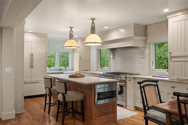 358 Jodytown Rd, Cashiers, NC 28717 - kitchen featuring stainless steel stove, custom range hood, a kitchen island, backsplash, and a breakfast bar