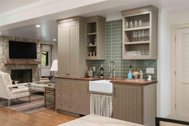 358 Jodytown Rd, Cashiers, NC 28717 - indoor wet bar featuring light wood-style flooring, decorative backsplash, and a stone fireplace