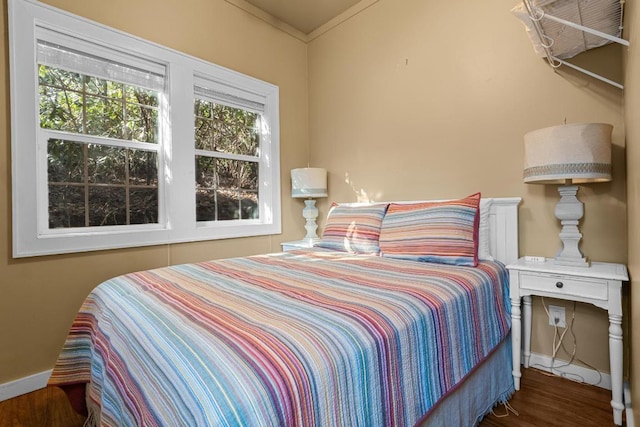 bedroom with ornamental molding and wood-type flooring