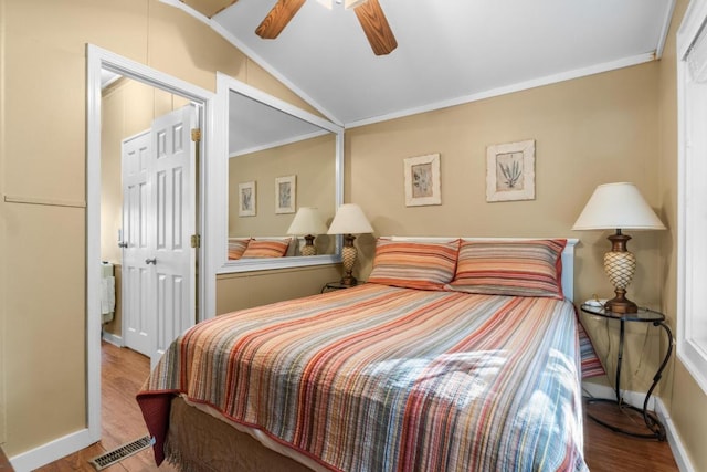 bedroom with light wood-type flooring, a closet, lofted ceiling, and crown molding