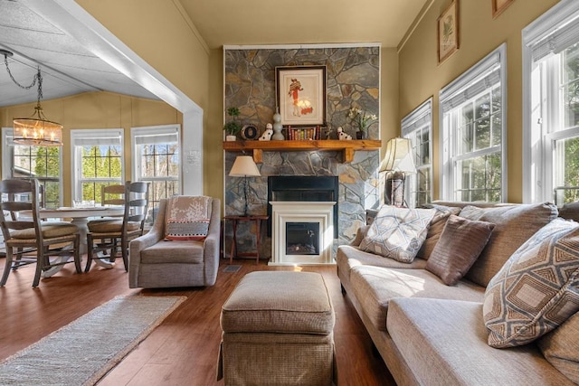 living room featuring dark hardwood / wood-style flooring, a large fireplace, a chandelier, and lofted ceiling