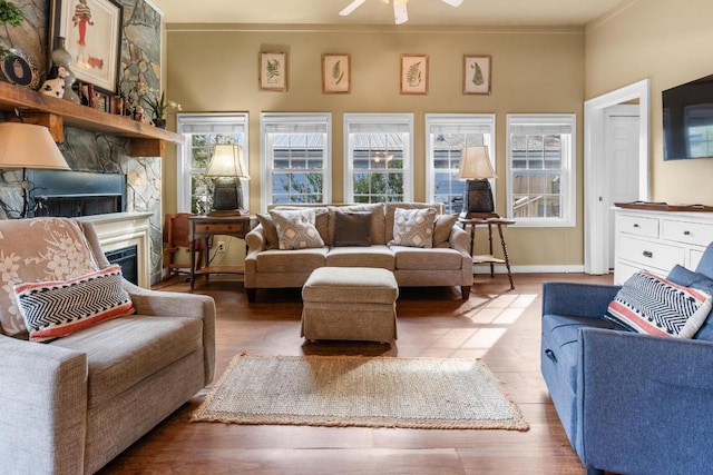 living room with a fireplace, ornamental molding, hardwood / wood-style floors, and ceiling fan