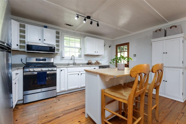 4860 Horse Cove Rd, Highlands, NC 28741 - kitchen featuring stainless steel appliances, a sink, light wood-style flooring, and healthy amount of natural light