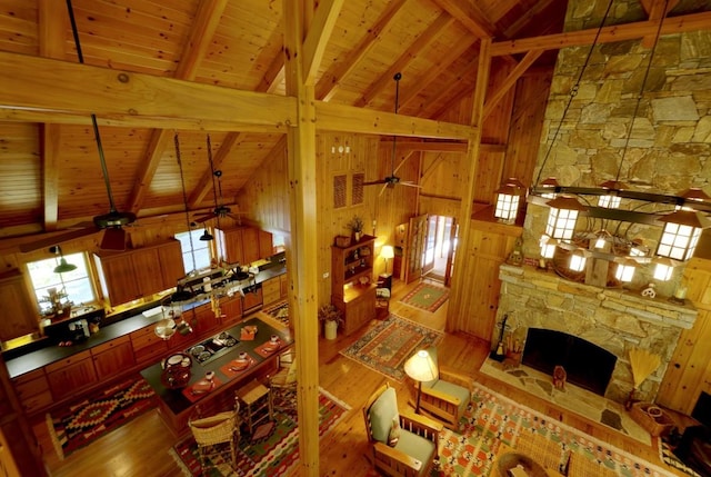 1528 Cold Mountain Rd, Lake Toxaway, NC 28747 - living room featuring wooden ceiling with exposed beams, a ceiling fan, wood finished floors, wood walls, and high vaulted ceiling