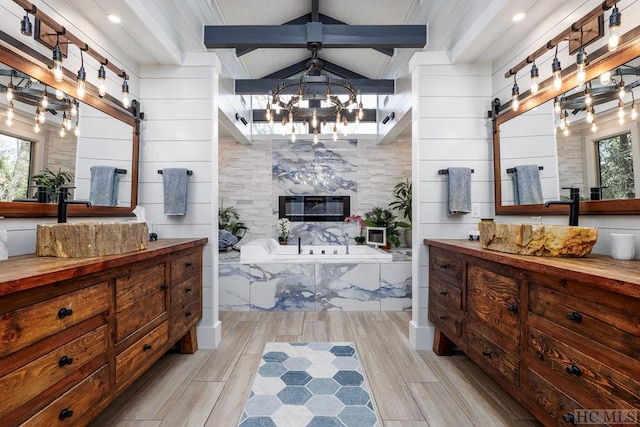 interior space featuring butcher block counters, a notable chandelier, a barn door, and beamed ceiling