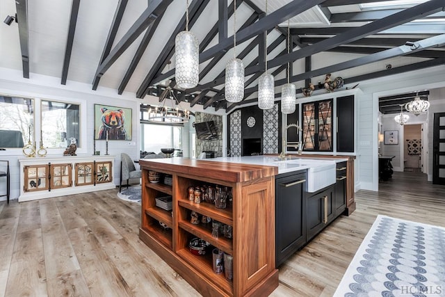 kitchen featuring beam ceiling, light hardwood / wood-style flooring, and high vaulted ceiling