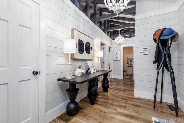 corridor featuring a notable chandelier and hardwood / wood-style flooring