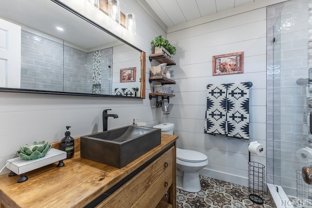 bathroom featuring vanity, a shower, tile patterned floors, and toilet