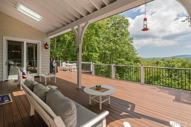 deck featuring an outdoor living space and a mountain view