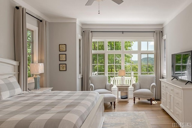 bedroom with crown molding, ceiling fan, and light hardwood / wood-style floors