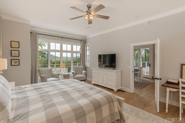 bedroom featuring multiple windows, ornamental molding, ceiling fan, and light hardwood / wood-style flooring