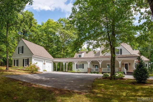 view of front of house with covered porch, a front lawn, and a garage