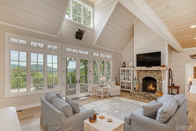 living room with light wood-type flooring, wooden walls, a wealth of natural light, and wood ceiling