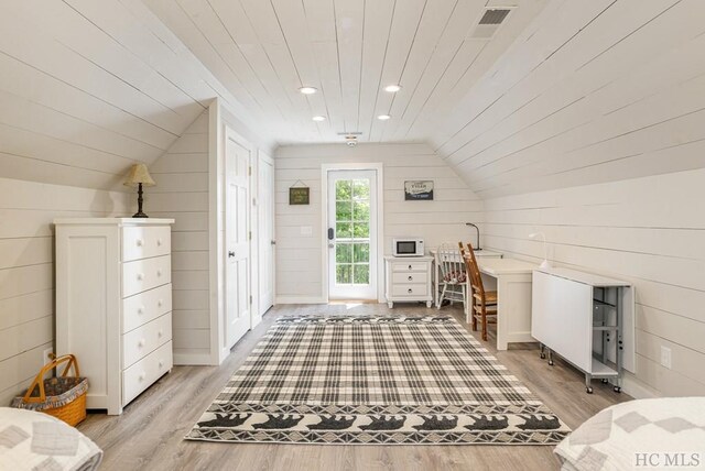 additional living space featuring vaulted ceiling, wooden ceiling, wood walls, and light wood-type flooring