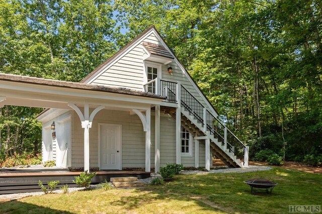 view of front of home with a front lawn and an outdoor fire pit