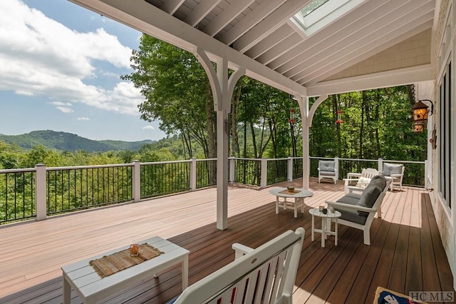 deck featuring outdoor lounge area and a mountain view