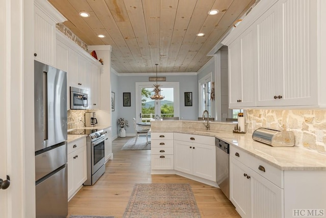 kitchen with white cabinetry, kitchen peninsula, hanging light fixtures, stainless steel appliances, and sink