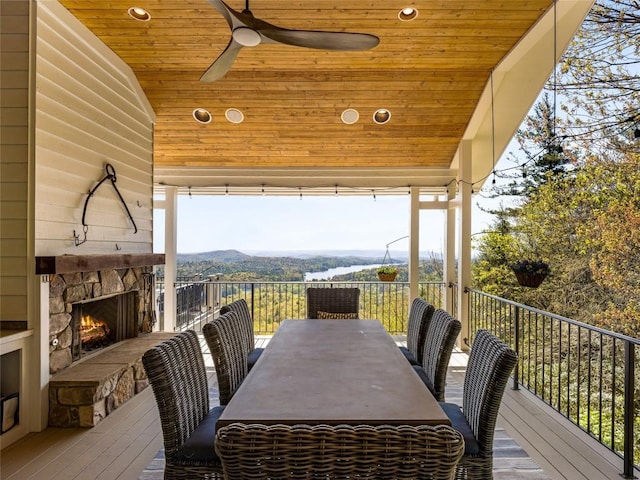 199 Mills Creek Point Rd, Lake Toxaway, NC 28747 - deck with an outdoor stone fireplace, a ceiling fan, a mountain view, and outdoor dining area