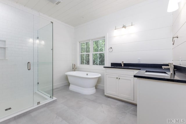 bathroom with vanity and shower with separate bathtub