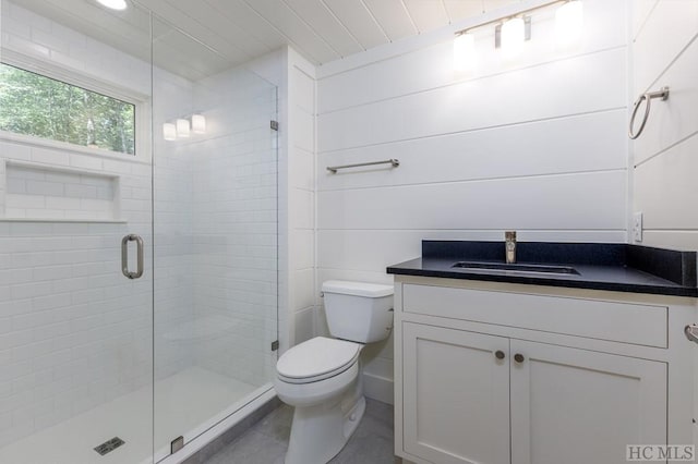 bathroom with vanity, a shower with door, and toilet