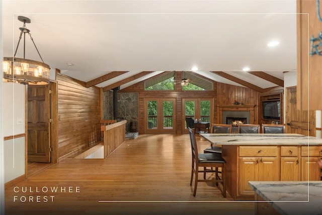 3398 Cullowhee Forest Rd, Cullowhee, NC 28723 - kitchen featuring a lit fireplace, wood walls, wood finished floors, open floor plan, and a breakfast bar area