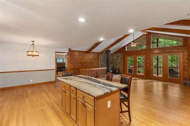 3398 Cullowhee Forest Rd, Cullowhee, NC 28723 - kitchen with a wood stove, a kitchen bar, open floor plan, light wood-type flooring, and a kitchen island