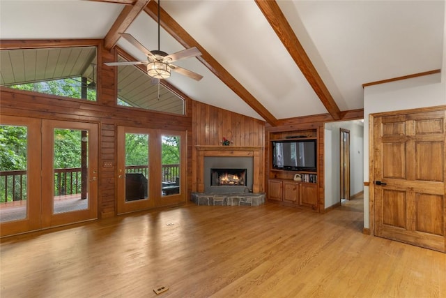 3398 Cullowhee Forest Rd, Cullowhee, NC 28723 - unfurnished living room with wood walls, light wood-style floors, a stone fireplace, and a ceiling fan