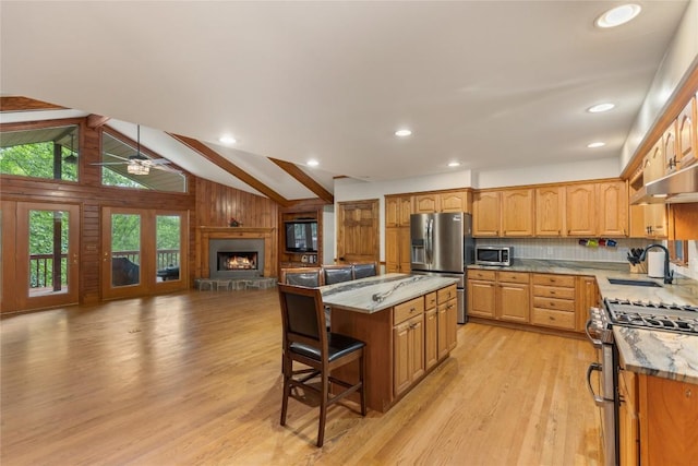 3398 Cullowhee Forest Rd, Cullowhee, NC 28723 - kitchen with stainless steel appliances, light wood-type flooring, open floor plan, a breakfast bar, and a center island