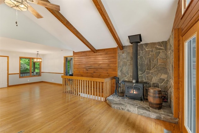 3398 Cullowhee Forest Rd, Cullowhee, NC 28723 - living room with wood finished floors, a wood stove, ceiling fan, beamed ceiling, and wood walls