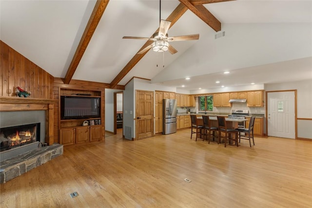 3398 Cullowhee Forest Rd, Cullowhee, NC 28723 - living area featuring a glass covered fireplace, ceiling fan, light wood finished floors, beam ceiling, and high vaulted ceiling
