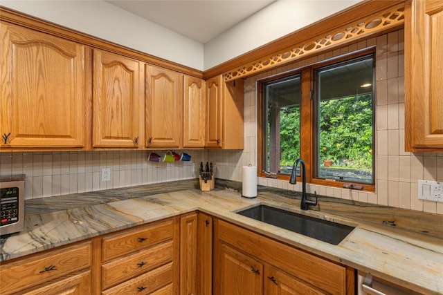 3398 Cullowhee Forest Rd, Cullowhee, NC 28723 - kitchen featuring backsplash, stainless steel microwave, light stone countertops, and brown cabinetry