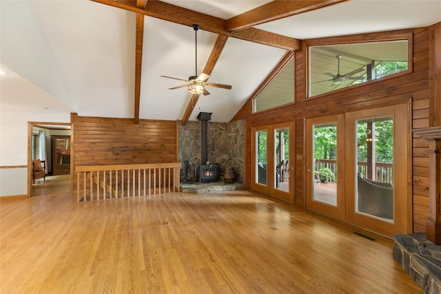 3398 Cullowhee Forest Rd, Cullowhee, NC 28723 - unfurnished living room with wood walls, a ceiling fan, a wood stove, and wood finished floors