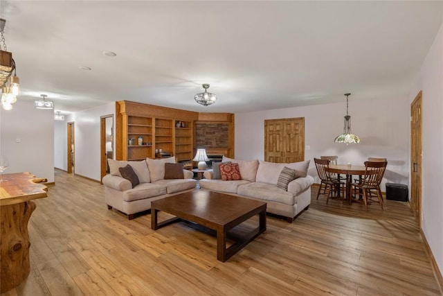 3398 Cullowhee Forest Rd, Cullowhee, NC 28723 - living room with a chandelier, light wood-type flooring, and a fireplace