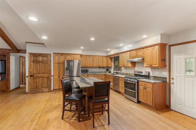 3398 Cullowhee Forest Rd, Cullowhee, NC 28723 - kitchen with stainless steel appliances, under cabinet range hood, light wood-style floors, a breakfast bar area, and a center island