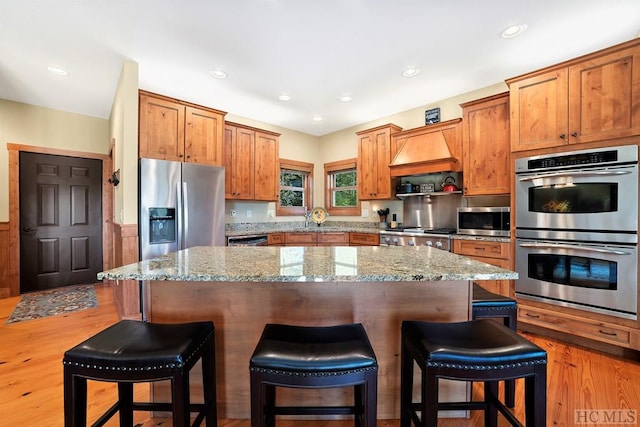 kitchen with stainless steel appliances, a center island, and a breakfast bar area