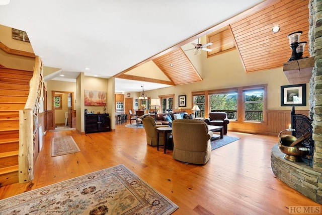 living room featuring ceiling fan with notable chandelier, lofted ceiling, and light hardwood / wood-style floors