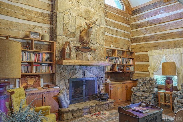 sitting room featuring wood-type flooring, a stone fireplace, and a high ceiling