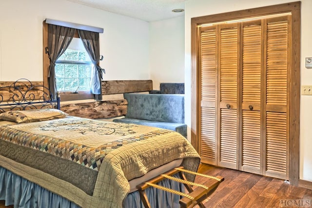 bedroom featuring a closet, dark hardwood / wood-style flooring, and a textured ceiling