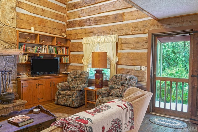 living area featuring hardwood / wood-style floors, a wealth of natural light, and a textured ceiling