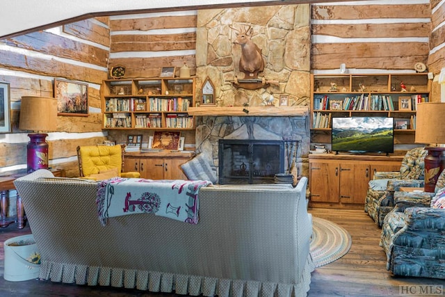 living room featuring a fireplace, wood-type flooring, and wooden walls