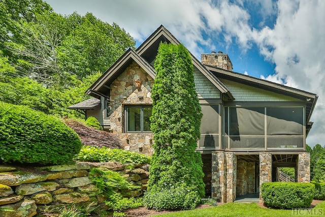 rear view of house featuring a sunroom