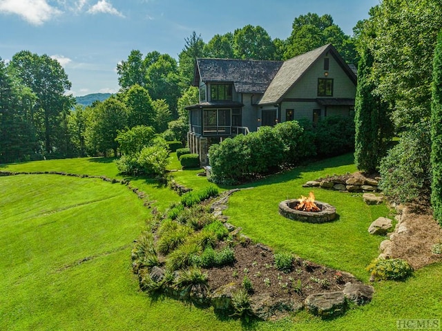 view of yard with a sunroom and an outdoor fire pit