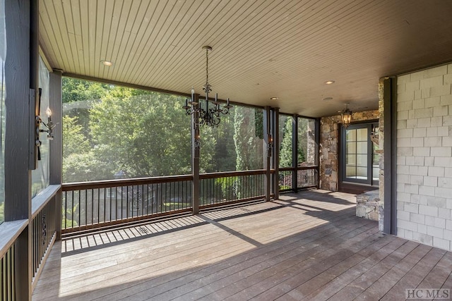 unfurnished sunroom with a healthy amount of sunlight and a chandelier