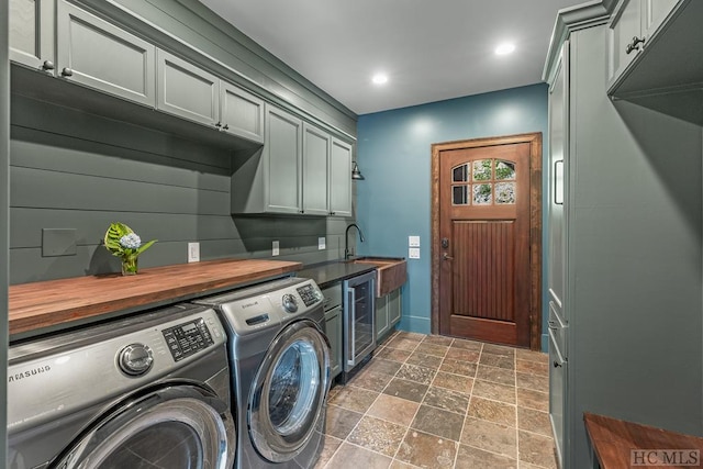 laundry area featuring cabinets, washing machine and dryer, and beverage cooler