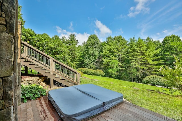 deck featuring a yard and a covered hot tub