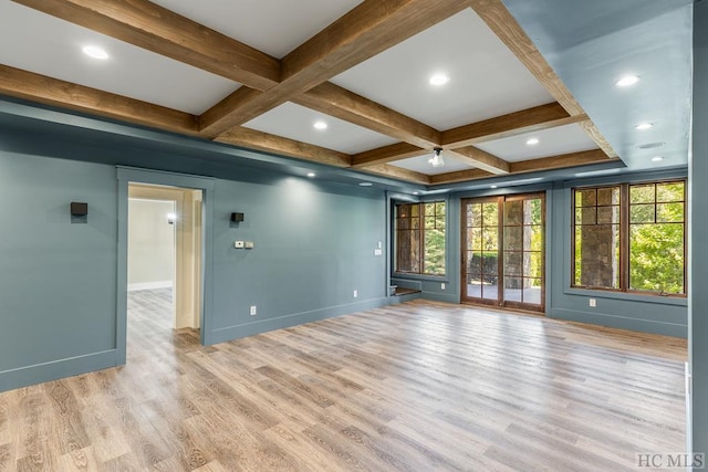 spare room featuring coffered ceiling, light hardwood / wood-style floors, and beam ceiling