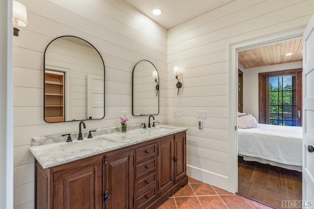 bathroom featuring vanity, wooden walls, and tile patterned flooring